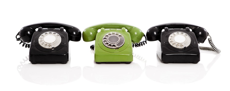 Green phone in the midle of two black phones, isolated on white background